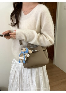 Détail du sac seau rétro taupe avec fermoir argenté et breloque chien en peluche doux