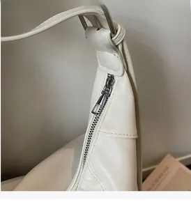 Détails de la fermeture éclair en métal argenté et coutures sur un sac blanc
