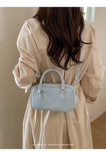 Light blue rectangular leather crossbody bag with gold hardware and top handles