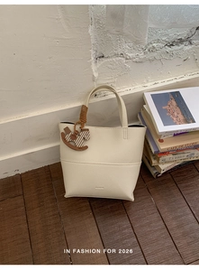 Détail du sac cabas blanc cassé en cuir grainé avec pendentif poney en bois et poignée
