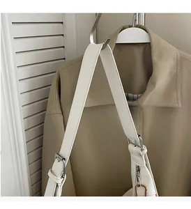 Détail de l'anse du sac en cuir blanc avec boucle argentée réglable et couture renforcée