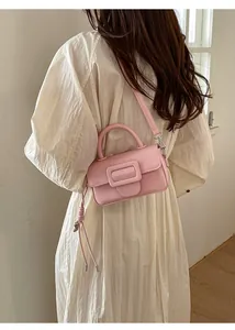 Borsa a mano rosa in similpelle con fibbia quadrata indossata da una modella