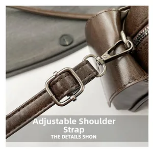Gros plan de la bandoulière réglable en cuir avec boucles métalliques pour le sac brun