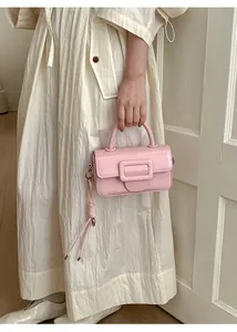 Dettaglio di una mini borsa rosa chiaro con fibbia quadrata e accessorio corda annodata