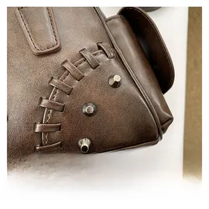Détail de la texture en cuir PU marron vintage avec rivets et coutures tressées
