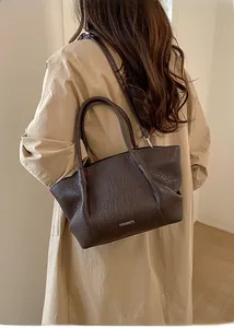 Vue détaillée du sac cabas marron foncé vintage avec texture froissée et logo argenté