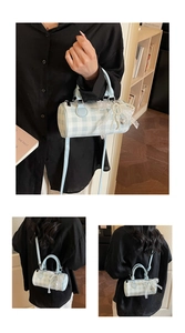 Détail du sac cylindrique à carreaux bleu clair avec dentelle et pendentif cœur