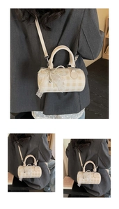 Détail du sac bowling beige avec nœuds en dentelle, breloques perles et motif à carreaux
