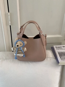 Minimalist vintage bucket bag in beige leather with cute bear charm and shoulder strap