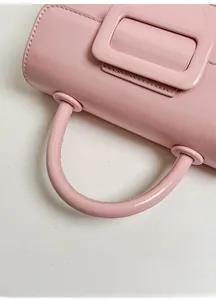 Dettaglio della borsa in ecopelle rosa con manico tondo e fibbia quadrata decorativa