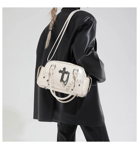 Détail du sac à main gothique blanc cassé avec croix noire et rivets argentés