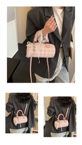 Détail du sac polochon à carreaux roses avec nœud en perles et pendentif cœur