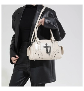 Gros plan du sac Boston gothique blanc cassé avec croix en métal et détails de chaîne