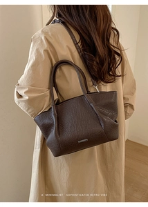 Détail du sac cabas en cuir grainé marron avec logo métallique et texture raffinée