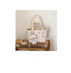 Détail du sac cabas à carreaux avec imprimé ours, bandoulière amovible et bijou de sac
