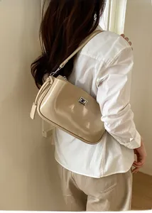 Elegante beige glänzende Unterarmtasche mit silberner Schnalle an der Schulter