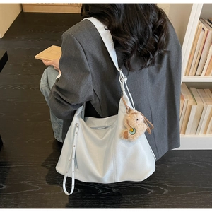 Détail du grand sac cabas en cuir bleu clair avec breloque alpaga et zip latéral