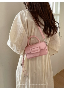 Vista posteriore di una borsa rosa minimalista con nappine laterali e fibbia quadrata