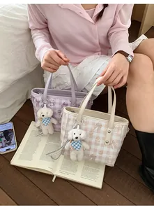 Gros plan de mini sacs cabas avec imprimés d'ours et pendentifs peluche sur parquet