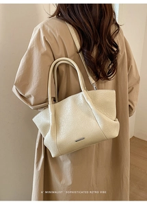 Sac fourre-tout crème minimaliste avec texture plissée et logo métallique au style rétro