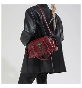 Sac bandoulière punk rouge bordeaux avec croix gothique et chaîne sur manteau en cuir noir