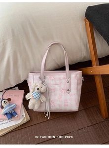 Détail du sac cabas avec motifs papillons embossés et pendentif chien en peluche