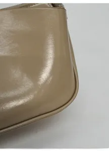 Makro-Detail der beigen Nappa-Leder Baguette-Tasche mit edlen Nähten und Reißverschluss