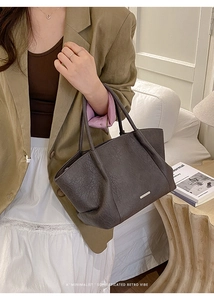 Gros plan sur le cuir marron rétro et le logo doré sur ce grand sac cabas chic