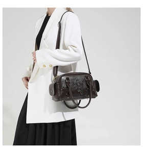 Détail du sac rétro marron foncé avec chaîne en croix et rivets métalliques