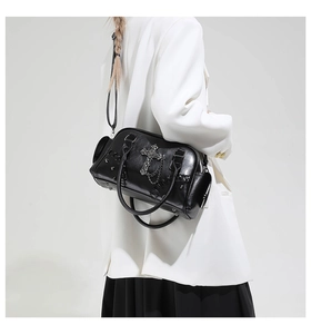 Vue latérale d'un sac porté épaule punk en cuir noir avec croix et chaîne sur mannequin