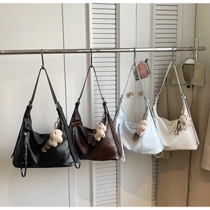 Sac Hobo en noir, marron, bleu et blanc avec de jolis pendentifs en peluche doux
