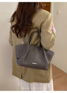 Sac fourre-tout rétro minimaliste en cuir grainé café foncé porté par un mannequin