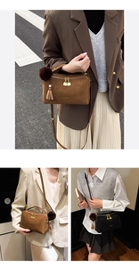 Detail der Vintage-Wildleder-Boston-Tasche mit Goldreißverschlüssen und Quastenanhänger