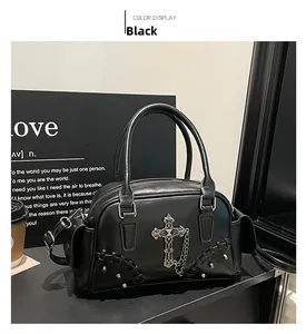 Détail du sac Boston gothique noir avec pendentif croix argentée et accents de chaîne