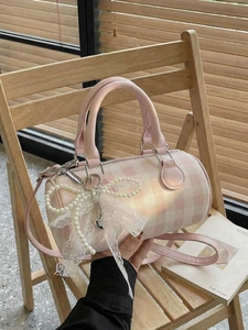 Sac à main Boston rose à carreaux avec nœud en dentelle et perles sur une chaise