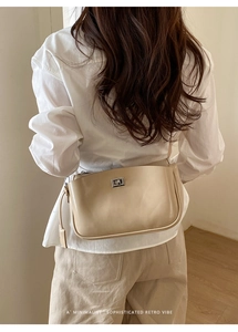 Schicke beige Umhängetasche aus Leder mit silbernem Drehverschluss und minimalistischem Design