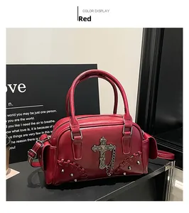 Détail du sac Boston gothique rouge avec croix en métal, rivets et chaînettes