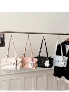 Détails de quatre sacs cabas élégants en crème, rose, noir et bleu avec breloque d'ours