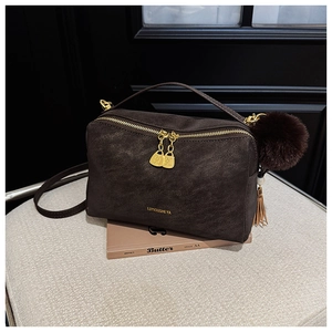 Detail der dunkelbraunen Retro-Handtasche mit goldener Doppel-Reißverschluss-Optik