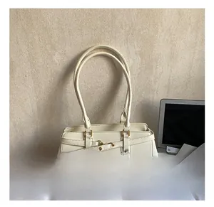 Detail of cream white shoulder bag featuring gold ring buckle and smooth PU leather
