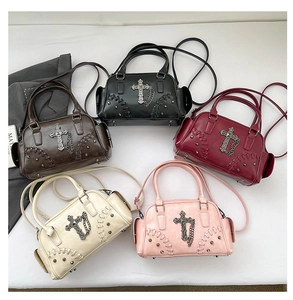 Détail de sacs Boston avec breloques croix en métal, rivets et plusieurs coloris