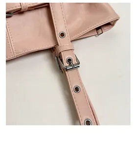Détail d'une bandoulière réglable en cuir rose avec boucle argentée et œillets