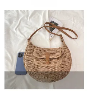 Détail du sac selle en paille tressée avec bandoulière en similicuir marron et rabat