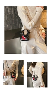 Detailed view of mini black quilted crossbody bag with red pony charm and chain strap