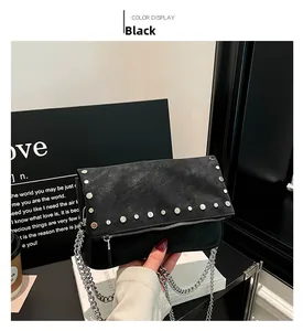 Détail du sac vintage en cuir noir avec clous argentés et bandoulière en chaîne