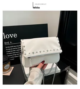Détail du sac rétro blanc avec clous argentés, chaîne métallique et fermeture éclair
