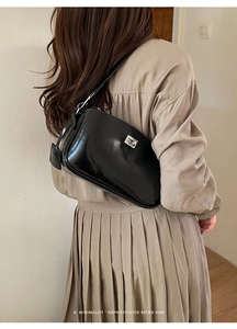 Detail einer klassischen schwarzen Leder-Schultertasche mit silberner Metallschnalle