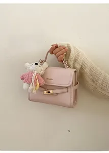Detailed close-up of a pink bucket bag with gold logo and plush bear charm accessory