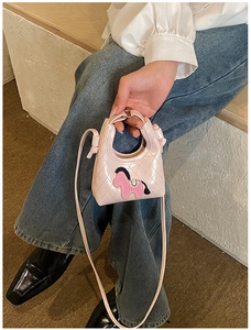 Detailed view of pink quilted mini bag with cartoon pony patch and shiny finish