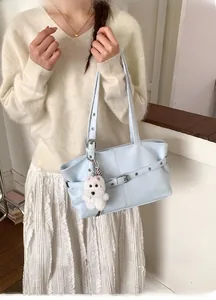 Détail du sac cabas bleu clair en similicuir avec boucle en métal et breloque peluche